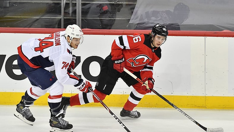 Apr 4, 2021; Newark, New Jersey, USA; New Jersey Devils center Jack Houghes (86) skates with the puck against Washington Capitals defenseman John Carlson (74) during the first period at Prudential Center. Mandatory Credit: Catalina Fragoso-USA TODAY Sports