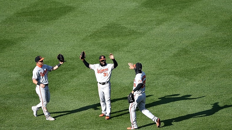 Apr 4, 2021; Boston, Massachusetts, USA; Baltimore Orioles left fielder Pat Valaika (11) center fielder Cedric Mullins (31) and right fielder Anthony Santander (25) react after defeating the Boston Red Sox at Fenway Park. Mandatory Credit: Bob DeChiara-USA TODAY Sports