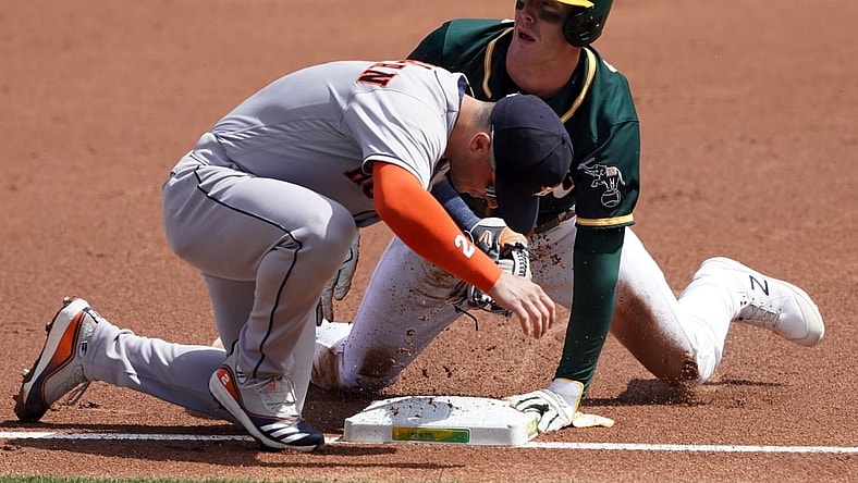 Apr 4, 2021; Oakland, California, USA; Oakland Athletics center fielder Mark Canha (20) slides into third base as Houston Astros third baseman Alex Bregman (2) applies a tag during the first inning at RingCentral Coliseum. Mandatory Credit: Darren Yamashita-USA TODAY Sports