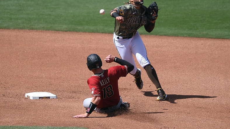 Apr 4, 2021; San Diego, California, USA; San Diego Padres shortstop Fernando Tatis Jr. (R) throws to first base after forcing out Arizona Diamondbacks catcher Carson Kelly (18) at second base during the fourth inning at Petco Park. Mandatory Credit: Orlando Ramirez-USA TODAY Sports