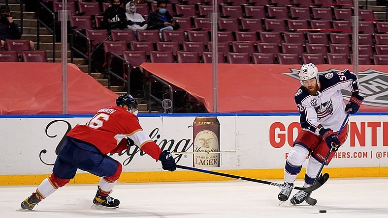 Apr 4, 2021; Sunrise, Florida, USA; Florida Panthers center Aleksander Barkov (16) reaches for the puck on Columbus Blue Jackets defenseman David Savard (58) during the first period at BB&T Center. Mandatory Credit: Jasen Vinlove-USA TODAY Sports