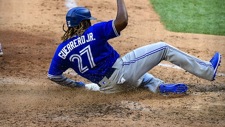 Apr 5, 2021; Arlington, Texas, USA; Toronto Blue Jays designated hitter Vladimir Guerrero Jr. (27) slides safely into home during the game between the Texas Rangers and the Toronto Blue Jays at Globe Life Field. Mandatory Credit: Jerome Miron-USA TODAY Sports