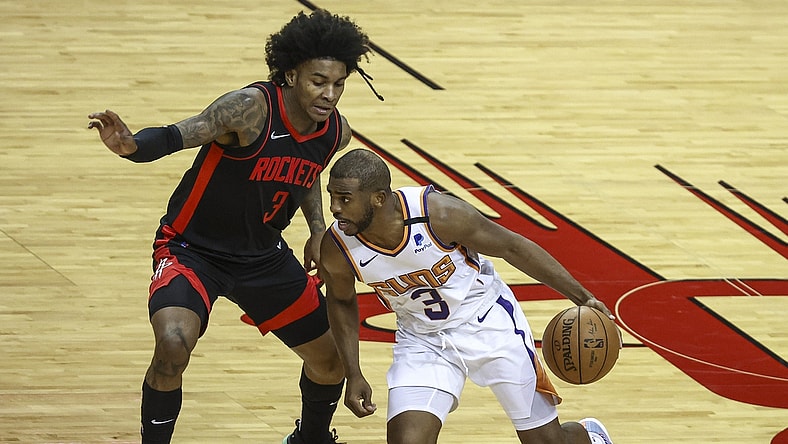 Apr 5, 2021; Houston, Texas, USA; Phoenix Suns guard Chris Paul (right) dribbles the ball against Houston Rockets guard Kevin Porter Jr. (left) during the third quarter at Toyota Center. Mandatory Credit: Troy Taormina-USA TODAY Sports