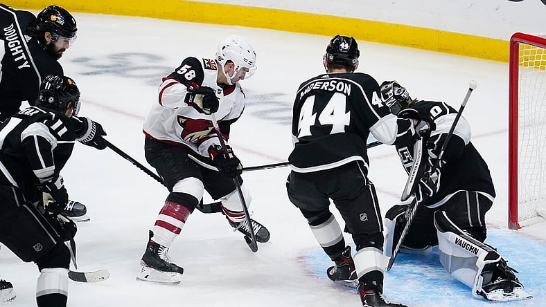 Apr 5, 2021; Los Angeles, California, USA; Arizona Coyotes Michael Bunting (58) pushes the puck past Los Angeles Kings defenseman Mikey Anderson (44) and Los Angeles Kings goaltender Calvin Petersen (40) to score during the first period at Staples Center. Mandatory Credit: Robert Hanashiro-USA TODAY Sports