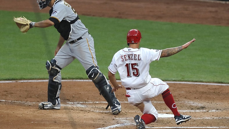 Apr 6, 2021; Cincinnati, Ohio, USA; Cincinnati Reds center fielder Nick Senzel (15) scores against Pittsburgh Pirates catcher Jacob Stallings (58) during the fourth inning at Great American Ball Park. Mandatory Credit: David Kohl-USA TODAY Sports