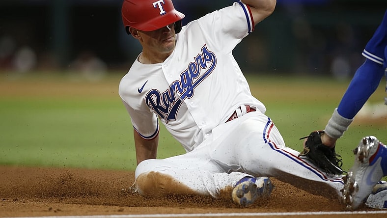 Apr 6, 2021; Arlington, Texas, USA; Texas Rangers second baseman Nick Solak (15) steals third base against Toronto Blue Jays third baseman Cavan Biggio (8) in the third inning at Globe Life Field. Mandatory Credit: Tim Heitman-USA TODAY Sports