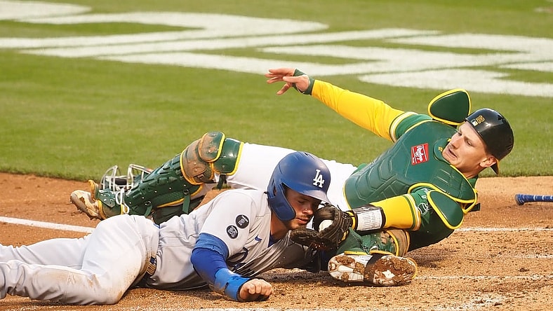 Apr 6, 2021; Oakland, California, USA; Oakland Athletics catcher Sean Murphy (12) tags out Los Angeles Dodgers second baseman Gavin Lux (9) at home during the second inning at RingCentral Coliseum. Mandatory Credit: Kelley L Cox-USA TODAY Sports