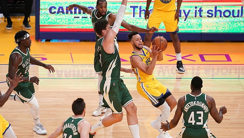 Apr 6, 2021; San Francisco, California, USA; Golden State Warriors guard Stephen Curry (30) drives past Milwaukee Bucks center Brook Lopez (11) in the first quarter at the Chase Center. Mandatory Credit: Cary Edmondson-USA TODAY Sports