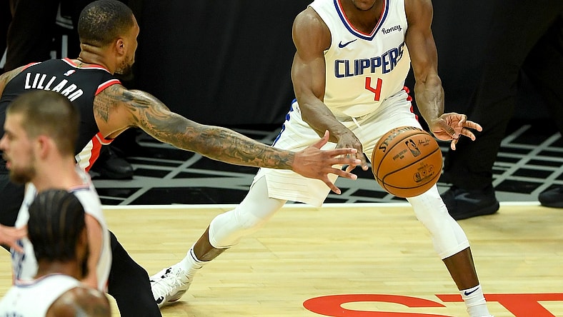 Apr 6, 2021; Los Angeles, California, USA; Los Angeles Clippers guard Rajon Rondo (4) is defended by Portland Trail Blazers guard Damian Lillard (0)as he passes the ball in the first half of the game at Staples Center. Mandatory Credit: Jayne Kamin-Oncea-USA TODAY Sports
