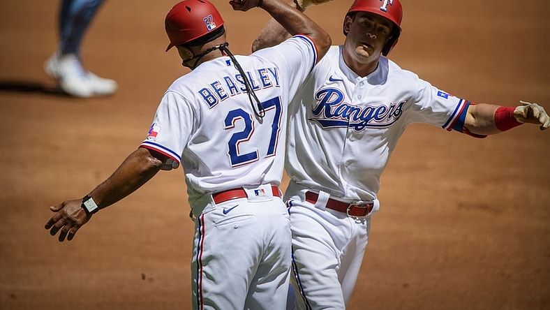 Apr 7, 2021; Arlington, Texas, USA; Texas Rangers third base coach Tony Beasley (27) and second baseman Nick Solak (15) celebrate Solak hitting a home run against the Toronto Blue Jays during the second inning at Globe Life Field. Mandatory Credit: Jerome Miron-USA TODAY Sports
