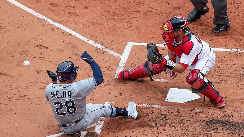 Apr 7, 2021; Boston, Massachusetts, USA; Tampa Bay Rays catcher Francisco Mejia (28) beats the throw home to Boston Red Sox catcher Kevin Plawecki (25) during the third inning at Fenway Park. Mandatory Credit: Paul Rutherford-USA TODAY Sports