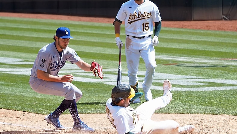 Apr 7, 2021; Oakland, California, USA; Oakland Athletics center fielder Ramon Laureano (22) slides safely home on a wild pitch by Los Angeles Dodgers starting pitcher Trevor Bauer (27) during the at bat of left fielder Seth Brown (15) during the fourth inning at RingCentral Coliseum. Mandatory Credit: Kelley L Cox-USA TODAY Sports