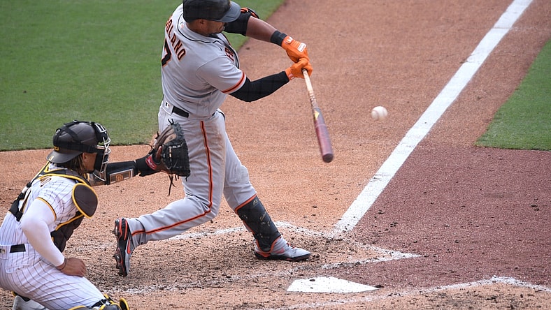 Apr 7, 2021; San Diego, California, USA; San Francisco Giants second baseman Donovan Solano (7) hits a sacrifice fly ball against the San Diego Padres during the tenth inning at Petco Park. Mandatory Credit: Orlando Ramirez-USA TODAY Sports