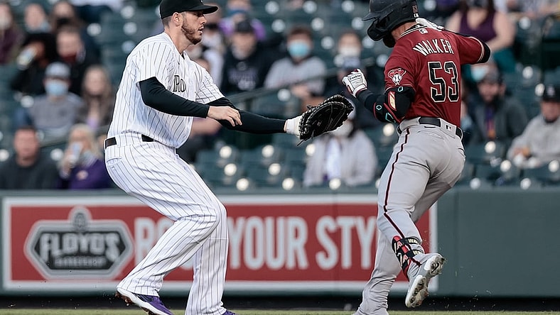 Apr 7, 2021; Denver, Colorado, USA; Colorado Rockies first baseman C.J. Cron (25) tags out Arizona Diamondbacks first baseman Christian Walker (53) in the first inning at Coors Field. Mandatory Credit: Isaiah J. Downing-USA TODAY Sports