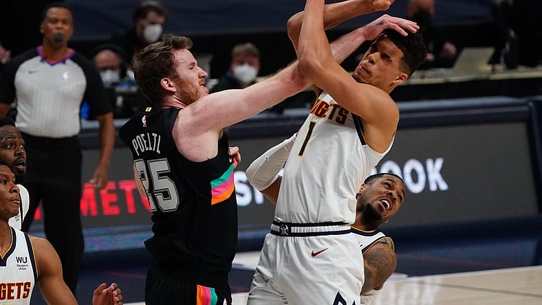Apr 7, 2021; Denver, Colorado, USA; San Antonio Spurs center Jakob Poeltl (25) collides into Denver Nuggets forward Michael Porter Jr. (1) in the first quarter at Ball Arena. Mandatory Credit: Ron Chenoy-USA TODAY Sports