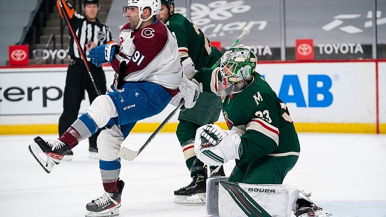 Apr 7, 2021; Saint Paul, Minnesota, USA;  Colorado Avalanche forward Nazem Kadri (91) is cross checked in front of Minnesota Wild goalie Cam Talbot (33) in the first period at Xcel Energy Center. Mandatory Credit: Brad Rempel-USA TODAY Sports