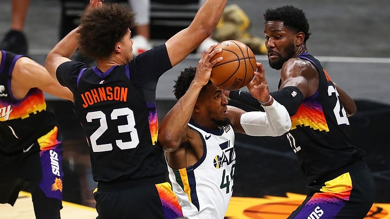 Apr 7, 2021; Phoenix, Arizona, USA; Utah Jazz guard Donovan Mitchell (27) drives to the basket against Phoenix Suns forward Cameron Johnson (23) and center Deandre Ayton (22) during the first half at Phoenix Suns Arena. Mandatory Credit: Mark J. Rebilas-USA TODAY Sports