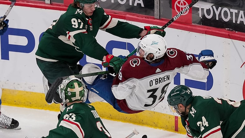 Apr 7, 2021; Saint Paul, Minnesota, USA;  Minnesota Wild forward Kirill Kaprizov (97) cross checks Colorado Avalanche forward Liam O'Brien (38) in the third period at Xcel Energy Center. Mandatory Credit: Brad Rempel-USA TODAY Sports