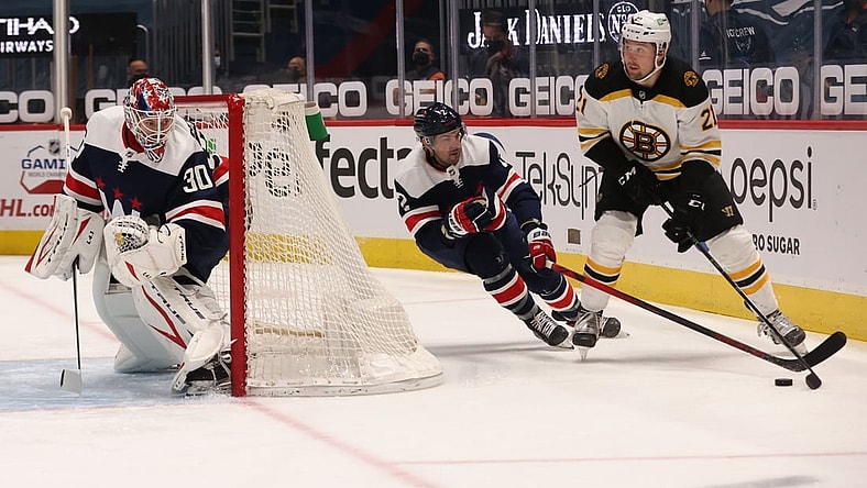 Apr 8, 2021; Washington, District of Columbia, USA; Boston Bruins left wing Nick Ritchie (21) skates with the puck behind Washington Capitals goaltender Ilya Samsonov (30) as Capitals defenseman Justin Schultz (2) defends in the first period at Capital One Arena. Mandatory Credit: Geoff Burke-USA TODAY Sports
