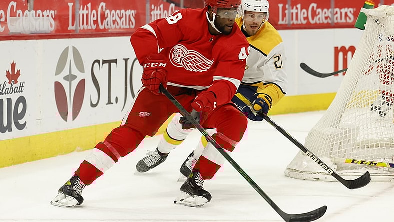 Apr 8, 2021; Detroit, Michigan, USA;  Detroit Red Wings left wing Givani Smith (48) skates with the puck chased by Nashville Predators center Nick Cousins (21) in the second period at Little Caesars Arena. Mandatory Credit: Rick Osentoski-USA TODAY Sports