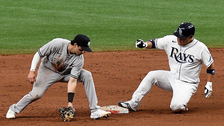 Apr 9, 2021; St. Petersburg, Florida, USA; Tampa Bay Rays designated hitter Yoshi Tsutsugo (25) slides into second base as New York Yankees infielder Tyler Wade (14) fields the throw from the outfield in the fifth inning at Tropicana Field. Mandatory Credit: Jonathan Dyer-USA TODAY Sports