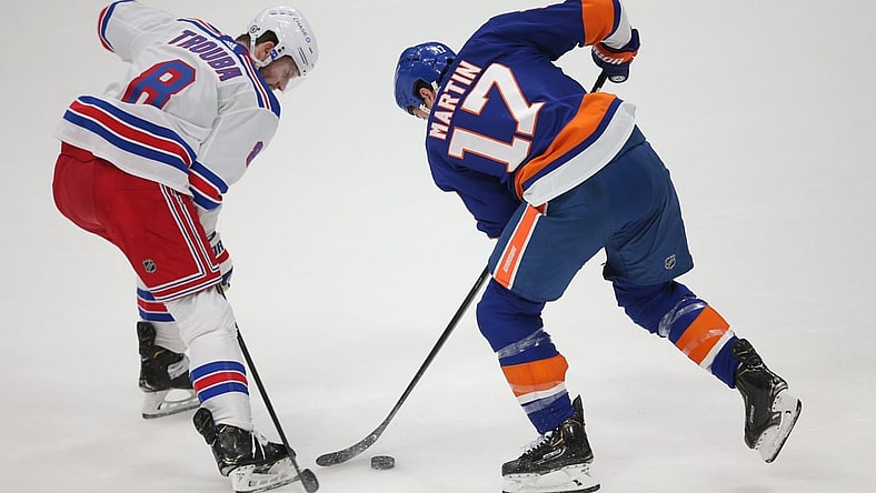 Apr 9, 2021; Uniondale, New York, USA; New York Rangers defenseman Jacob Trouba (8) and New York Islanders left wing Matt Martin (17) fight for the puck during the first period at Nassau Veterans Memorial Coliseum. Mandatory Credit: Brad Penner-USA TODAY Sports