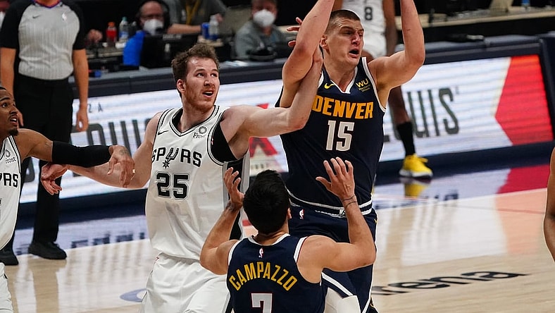 Apr 9, 2021; Denver, Colorado, USA; Denver Nuggets center Nikola Jokic (15) pulls a rebound away from San Antonio Spurs center Jakob Poeltl (25) in the third quarter at Ball Arena. Mandatory Credit: Ron Chenoy-USA TODAY Sports