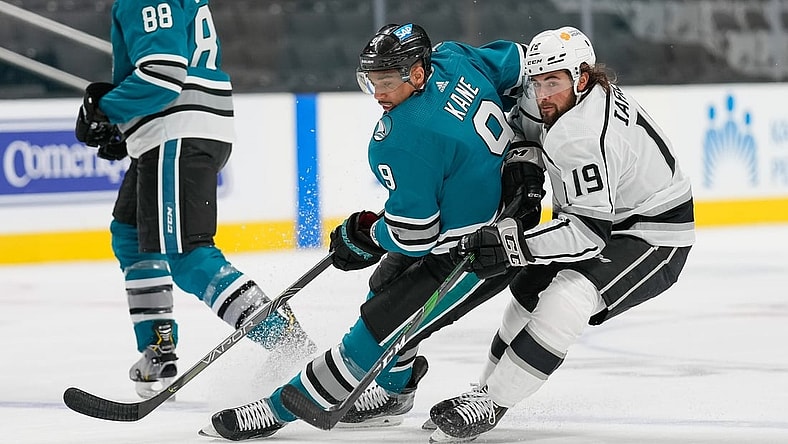 Apr 9, 2021; San Jose, California, USA; San Jose Sharks left wing Evander Kane (9) and Los Angeles Kings right wing Alex Iafallo (19) chase after the puck during the first period at SAP Center at San Jose. Mandatory Credit: Stan Szeto-USA TODAY Sports