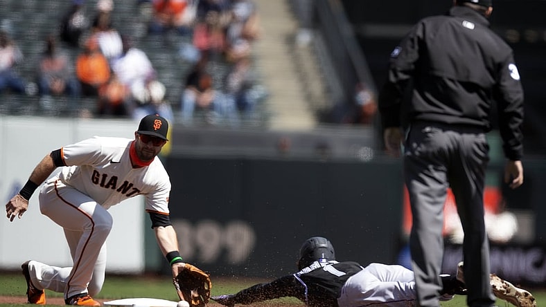 Apr 10, 2021; San Francisco, California, USA; Colorado Rockies fielder Garrett Hampson (1) is caught stealing second base by San Francisco Giants third baseman Evan Longoria (L) as umpire Pat Hoberg (R) looks on during the first inning at Oracle Park. Mandatory Credit: D. Ross Cameron-USA TODAY Sports