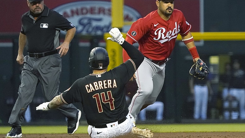 Apr 10, 2021; Phoenix, Arizona, USA; Arizona Diamondbacks third baseman Asdrubal Cabrera (14) slides into second base safely against Cincinnati Reds third baseman Eugenio Suarez (7) during a game at Chase Field. Mandatory Credit: Rick Scuteri-USA TODAY Sports