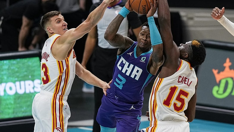 Apr 11, 2021; Charlotte, North Carolina, USA; Charlotte Hornets guard Terry Rozier (3) gets fouled going up for a shot defended by Atlanta Hawks center Clint Capela (15) and guard Bogdan Bogdanovic (13) during the second quarter at Spectrum Center. Mandatory Credit: Jim Dedmon-USA TODAY Sports