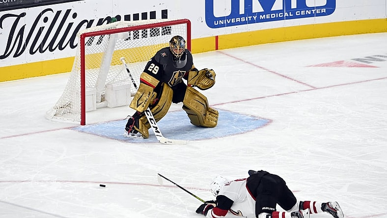 Apr 11, 2021; Las Vegas, NV, USA; Arizona Coyotes right wing Clayton Keller (9) slips on the ice as Vegas Golden Knights goaltender Marc-Andre Fleury (29) defends during the second period at T-Mobile Arena. (Mandatory Credit: David Beckeri-USA TODAY Sports via The Associated Press)