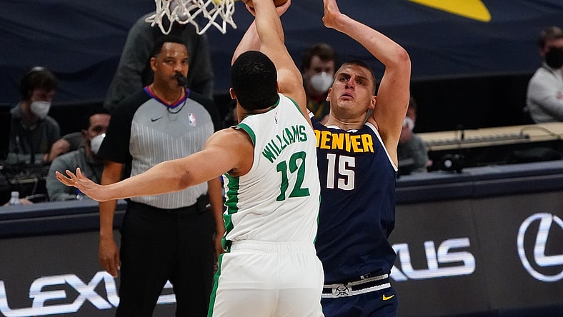 Apr 11, 2021; Denver, Colorado, USA; Boston Celtics forward Grant Williams (12) blocks the shot of Denver Nuggets center Nikola Jokic (15) in the fourth quarter at Ball Arena. Mandatory Credit: Ron Chenoy-USA TODAY Sports