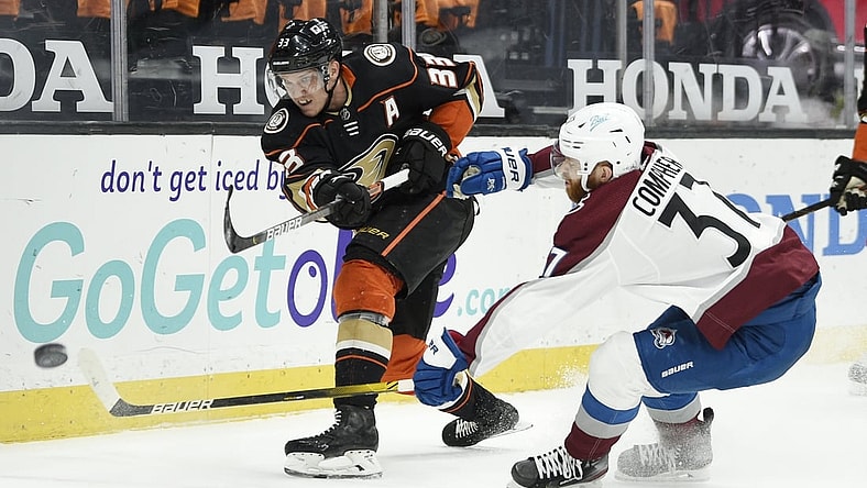 Apr 11, 2021; Anaheim, California, USA; Anaheim Ducks right wing Jakob Silfverberg (33) clears the puck away from Colorado Avalanche left wing J.T. Compher (37) during the first period at Honda Center. Mandatory Credit: Kelvin Kuo-USA TODAY Sports