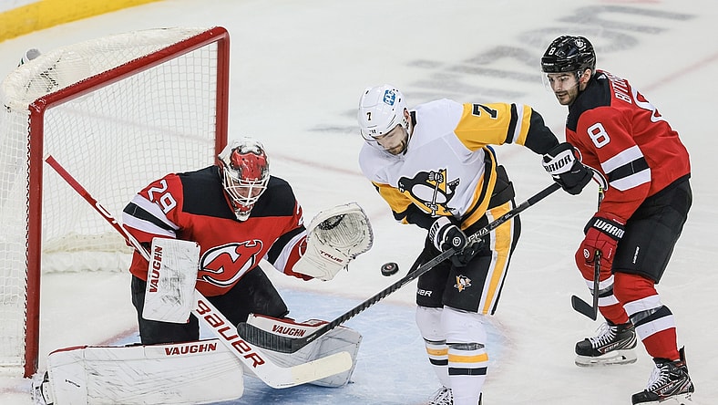 Apr 11, 2021; Newark, New Jersey, USA; Pittsburgh Penguins center Colton Sceviour (7) deflects a shot in front of New Jersey Devils goaltender Mackenzie Blackwood (29) and defenseman Will Butcher (8) during the second period at Prudential Center. Mandatory Credit: Vincent Carchietta-USA TODAY Sports
