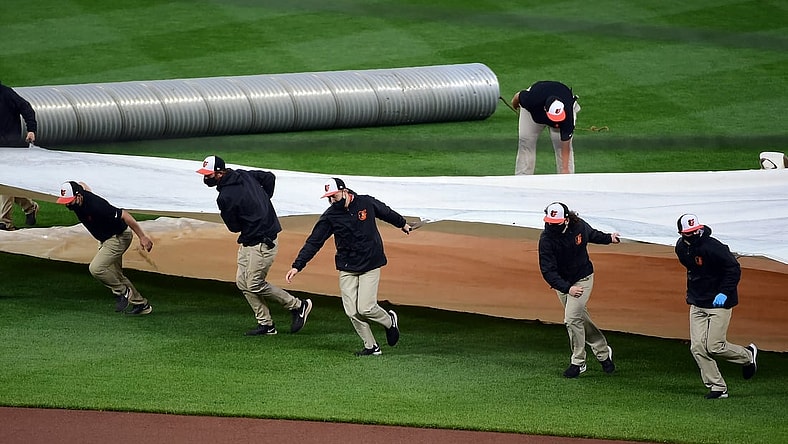 Apr 12, 2021; Baltimore, Maryland, USA; Members of the grounds crew put the tarp on the field prior to a game between the Seattle Mariners and Baltimore Orioles at Oriole Park at Camden Yards. Mandatory Credit: Evan Habeeb-USA TODAY Sports