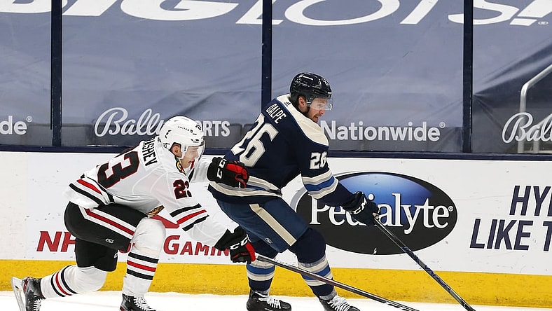 Apr 12, 2021; Columbus, Ohio, USA; Columbus Blue Jackets center Zac Dalpe (26) skates around Chicago Blackhawks center Philipp Kurashev (23) during the first period at Nationwide Arena. Mandatory Credit: Russell LaBounty-USA TODAY Sports