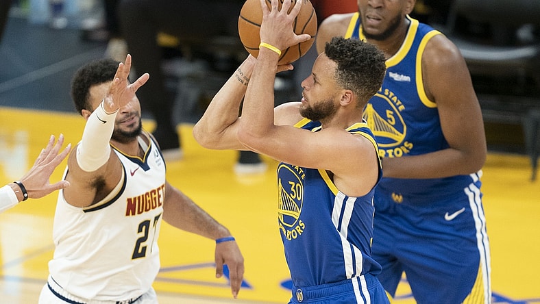 April 12, 2021; San Francisco, California, USA; Golden State Warriors guard Stephen Curry (30) shoots the basketball against Denver Nuggets guard Jamal Murray (27) during the first quarter at Chase Center. Mandatory Credit: Kyle Terada-USA TODAY Sports