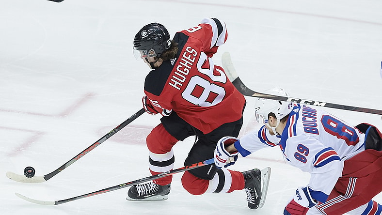 Apr 13, 2021; Newark, New Jersey, USA; New Jersey Devils center Jack Hughes (86) skates with the puck against New York Rangers right wing Pavel Buchnevich (89) during the first period at Prudential Center. Mandatory Credit: Vincent Carchietta-USA TODAY Sports