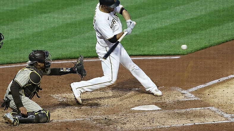 Apr 13, 2021; Pittsburgh, Pennsylvania, USA; Pittsburgh Pirates catcher Jacob Stallings (R) hits an RBI single against the San Diego Padres during the second inning at PNC Park. Mandatory Credit: Charles LeClaire-USA TODAY Sports
