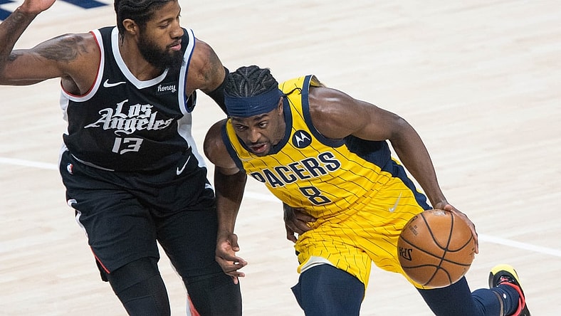 Apr 13, 2021; Indianapolis, Indiana, USA; Indiana Pacers forward Justin Holiday (8) dribbles the ball while LA Clippers guard Paul George (13) defends  in the first quarter at Bankers Life Fieldhouse. Mandatory Credit: Trevor Ruszkowski-USA TODAY Sports