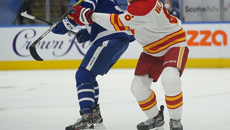 Apr 13, 2021; Toronto, Ontario, CAN; Calgary Flames defenseman Juuso Valimaki (6) battles for position with Toronto Maple Leafs forward Joe Thornton (97) during the first period at Scotiabank Arena. Mandatory Credit: John E. Sokolowski-USA TODAY Sports