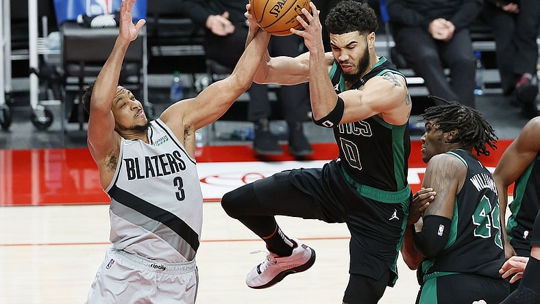 Apr 13, 2021; Portland, Oregon, USA; Portland Trail Blazers shooting guard CJ McCollum (3) and Boston Celtics small forward Jayson Tatum (0) battle for a rebound during the second half at Moda Center. Mandatory Credit: Soobum Im-USA TODAY Sports