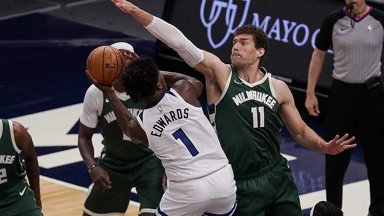 Apr 14, 2021; Minneapolis, Minnesota, USA; Milwaukee Bucks center Brook Lopez (11) defends Minnesota Timberwolves guard Anthony Edwards (1) in the first quarter at Target Center. Mandatory Credit: Brad Rempel-USA TODAY Sports