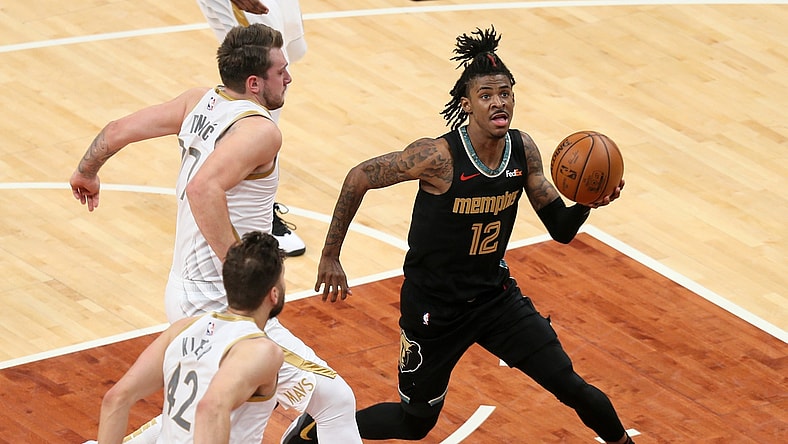 Apr 14, 2021; Memphis, Tennessee, USA; Memphis Grizzlies guard Ja Morant (12) drives to the basket as  Dallas Mavericks guard Luka Doncic (77) defends during the second quarter at FedExForum. Mandatory Credit: Nelson Chenault-USA TODAY Sports