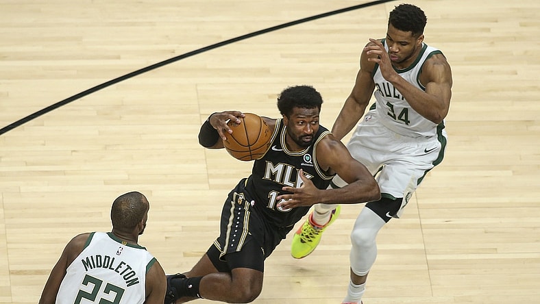 Apr 15, 2021; Atlanta, Georgia, USA; Atlanta Hawks forward Solomon Hill (18) drives on Milwaukee Bucks forward Giannis Antetokounmpo (34) and forward Khris Middleton (22) in the second quarter at State Farm Arena. Mandatory Credit: Brett Davis-USA TODAY Sports