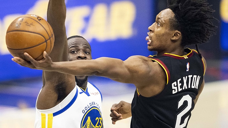 Apr 15, 2021; Cleveland, Ohio, USA; Cleveland Cavaliers guard Collin Sexton (2) lays the ball up past Golden State Warriors forward Draymond Green (23) during the first quarter at Rocket Mortgage FieldHouse. Mandatory Credit: Scott Galvin-USA TODAY Sports