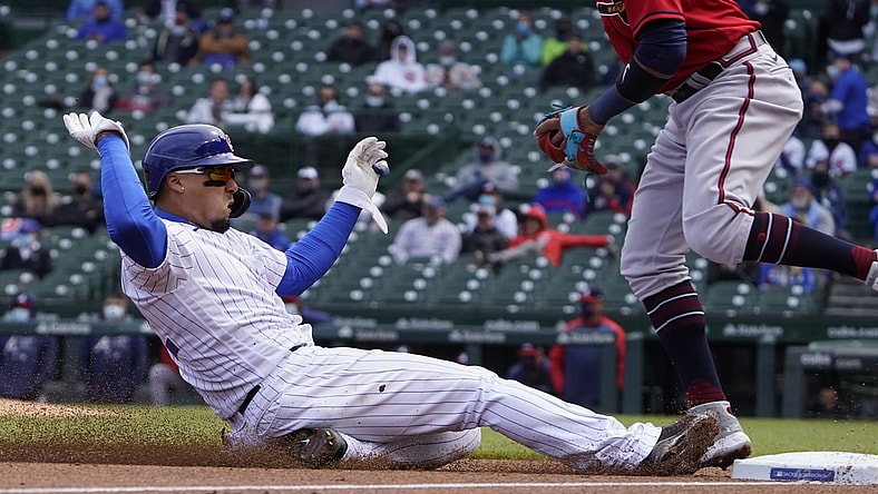 Apr 16, 2021; Chicago, Illinois, USA; Chicago Cubs shortstop Javier Baez slides safely into third base against the Atlanta Braves during the second inning at Wrigley Field. All players on both teams are wearing number 42 in honor of Jackie Robinson Day. Mandatory Credit: David Banks-USA TODAY Sports
