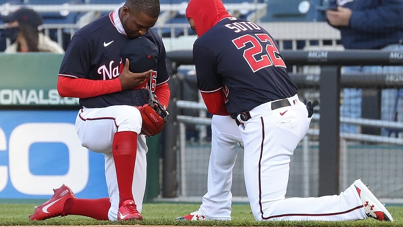Apr 16, 2021; Washington, District of Columbia, USA; Washington Nationals center fielder Victor Robles (16) and Nationals left fielder Juan Soto (22) kneel in prayer prior to their game against the Arizona Diamondbacks at Nationals Park. Mandatory Credit: Geoff Burke-USA TODAY Sports