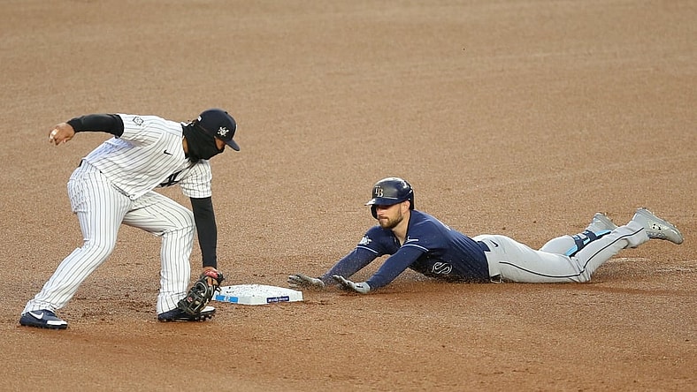 Apr 16, 2021; Bronx, New York, USA; Tampa Bay Rays second baseman Brandon Lowe slides safely into second with a two-run double ahead of the tag by New York Yankees shortstop Gleyber Torres during the first inning at Yankee Stadium. Mandatory Credit: Brad Penner-USA TODAY Sports